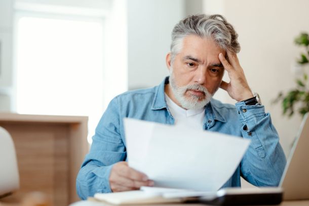 A person with a surprised expression looking at a piece of paper.